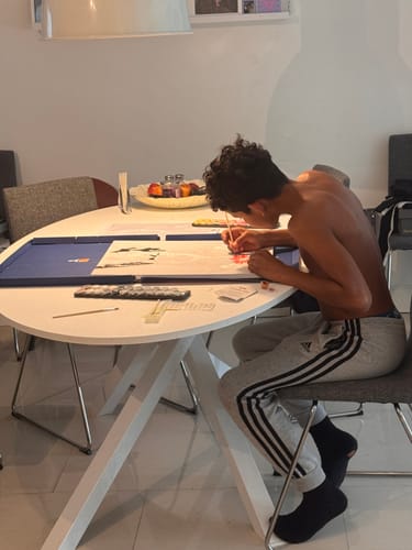 Reviewer at a table using the Professional Brushes to work on a large paint-by-numbers canvas.