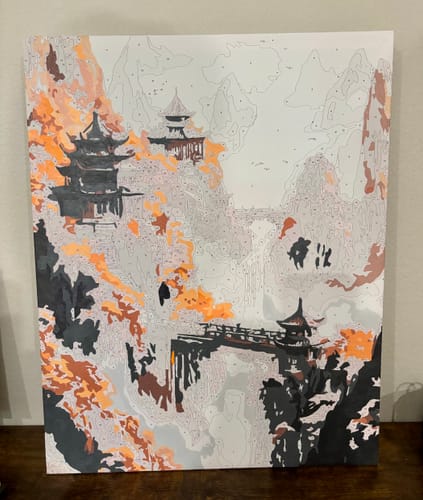 Customer's Mountain Pagoda paint-by-numbers kit in progress, with grey, black and orange paint applied to the mountain scene.