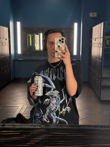 Reviewer in a locker room showing the oversized fit of the black Yu-Gi-Oh!® Tee in a mirror selfie.