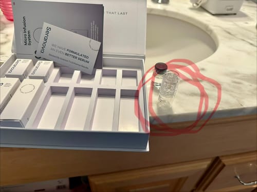 Reviewer's Micro Infusion System unboxed on a counter, with the infusion device and a serum vial next to the open packaging.