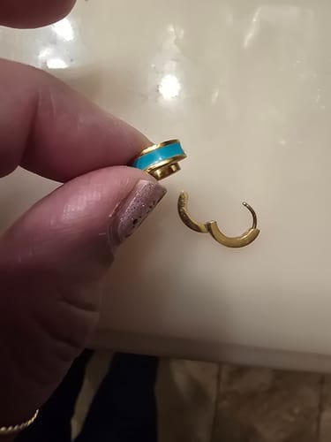 Customer's hand holding the Leigh Teal Hoop Earring open to show the clasp mechanism.