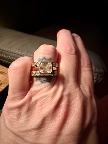 Close-up of a reviewer's hand wearing a two-ring gold set featuring a large Asscher Cut Lab Diamond.