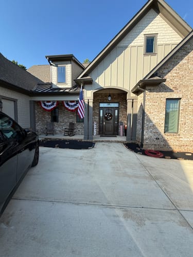 Customer's Prestige House Flag Pole kit with the American flag mounted on the front pillar of a modern brick home.
