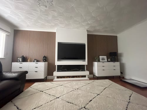Customer's living room with the Premium Acoustic Slatted Wall Panels installed as a stylish feature wall around a media unit.