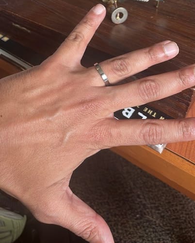 Reviewer's hand wearing the simple and understated 3mm Flat Wedding Band.