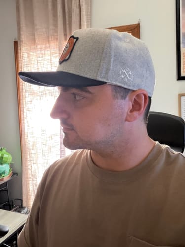 Customer wearing the light grey Big Flat Bill Structured Wool Hat with a dark bill, showing a side profile view.