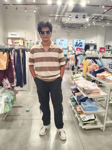 Reviewer standing in a clothing store wearing white EVOLVE sneakers with black cargo pants.
