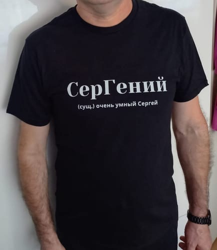 Reviewer wearing the black Sergei Tee, showing the accurate fit and white printed text.