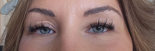 Kundin zeigt ihre Augen in Nahaufnahme mit den auffälligen Manga Muse Wimpernextensions.