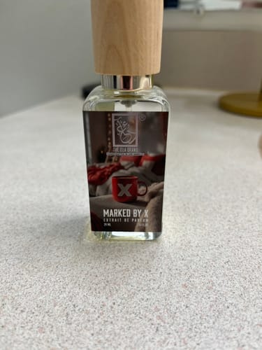 Customer photo of a Dua Marked By X bottle with a wooden cap on a speckled countertop