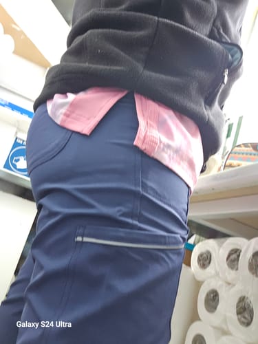 Un cliente usa el pantalón clínico Cherokee Infinity, mostrando el ajuste y el bolsillo cargo con cremallera lateral.