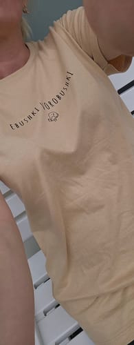 A customer wearing the light yellow Vorobushki Tee, showing the chest graphic.