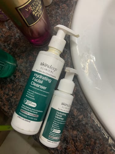 Customer's large and small bottles of Hydrating Facial Cleanser on a bathroom counter.