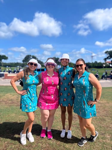 Customer and three others on a golf course wearing custom print golf dresses in turquoise and pink.