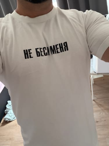 Reviewer wearing the white Ne besi Tee, showing the fit and the black text on the chest.