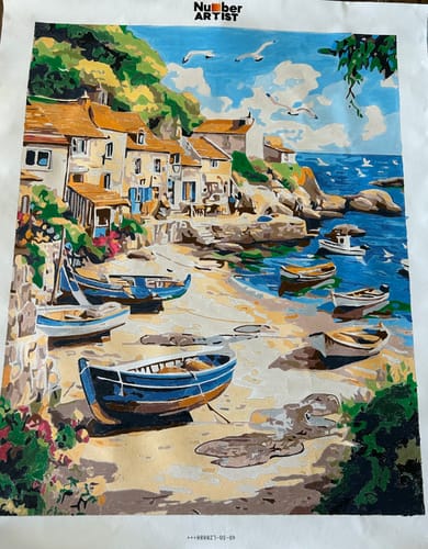 Reviewer's completed Fisherman Village paint-by-numbers project, showing a vibrant village with boats on the shore.
