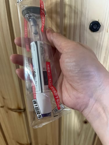 購入者がパッケージに入ったマンジャロ注射器を手に持っている様子。