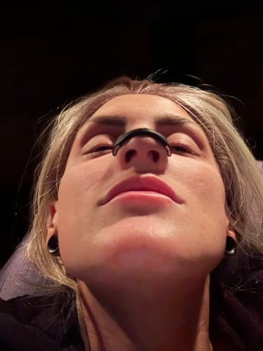 Reviewer from a low angle wearing the black Magnetic TERVENCE® Band on their nose.