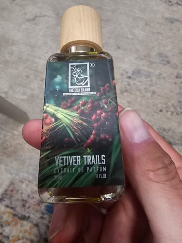 Customer holding a Dua Vetiver Trails bottle with a light wood cap