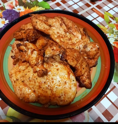 Client prezentând piept de pui rumenit, gătit cu friteuza cu aer cald Novio StonePro.