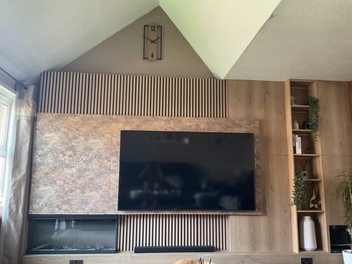 Customer's finished media wall featuring Premium Acoustic Slatted Wall Panels surrounding a large television.