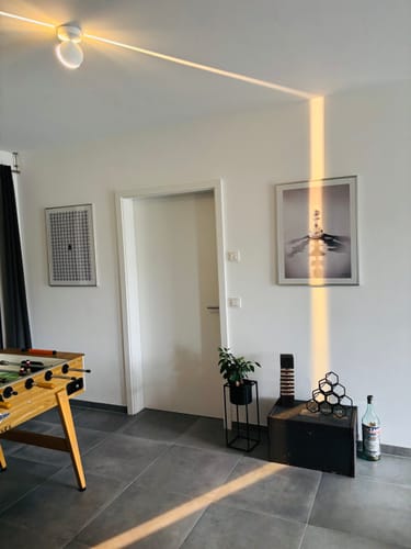 Customer's 'Hidden Potential' art print hanging on a white wall in a modern room with a foosball table.