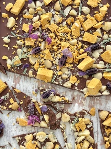 Customer's close-up of chocolate bark topped with freeze dried edible lavender, honeycomb, and nuts.