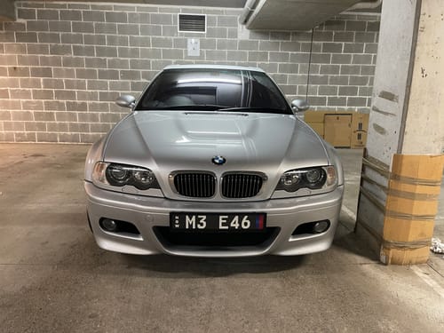 Customer's silver BMW M3 E46 with a Euro Premium Number Plate Bracket installed on the front bumper in a garage.
