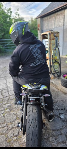 Reviewer seen from the back wearing the black In FnD We Trust Stealth Hoodie while on a motorcycle.