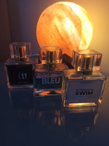 Customer's photo of three glass perfume bottles arranged in front of a glowing lamp.