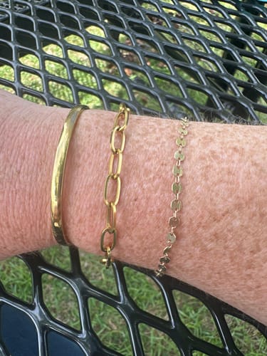 Customer wearing three gold bracelets from the WaterProof Jewelry Bundle on their wrist.