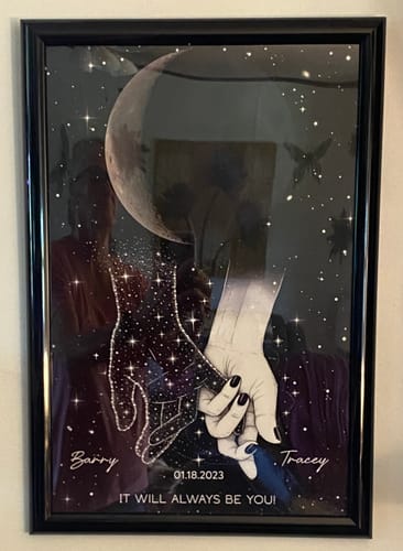 Customer's personalized memorial poster in a black frame, showing the custom holding hands and moon design.