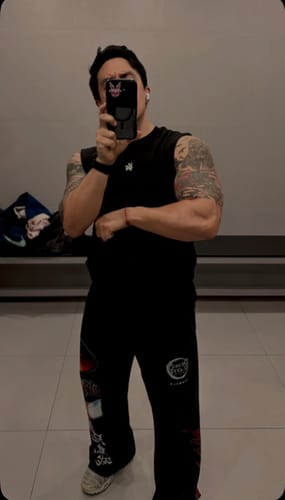 Reviewer wearing a size S black RunTech Tank while taking a mirror selfie in a gym.