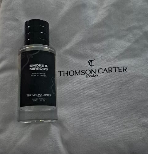 Customer's Smoke & Mirrors Eau de Parfum bottle shown next to its branded cloth storage bag.