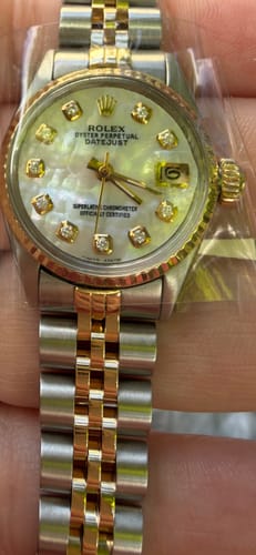 Customer's close-up view of the Rolex Lady Datejust Watch, showing its mother of pearl dial and two-tone bracelet.