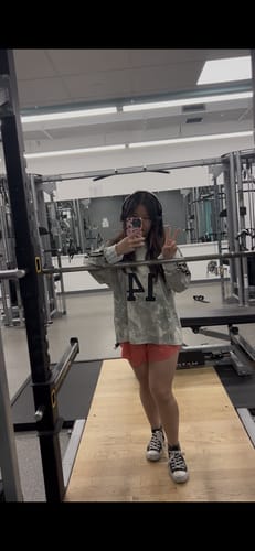 Reviewer in a gym wearing the oversized W4302 Camo Longsleeve Jersey.