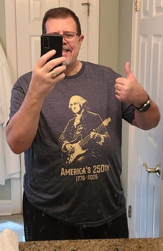Reviewer wearing the dark gray Washington 250 T-Shirt, taking a mirror selfie and giving a thumbs up.
