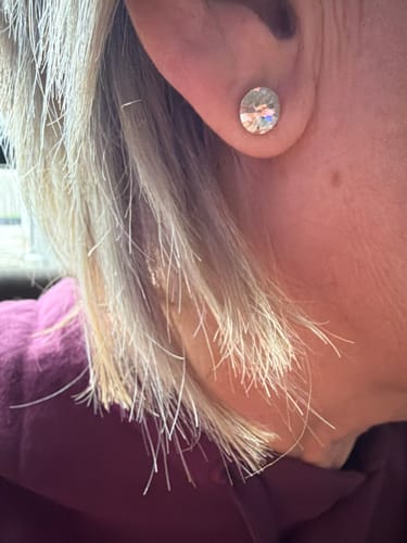 Close-up of a reviewer wearing a sparkly oval stud earring from their Surprise Box.