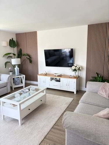 Customer's light wood acoustic slatted panels installed as a stylish feature wall in a living room.