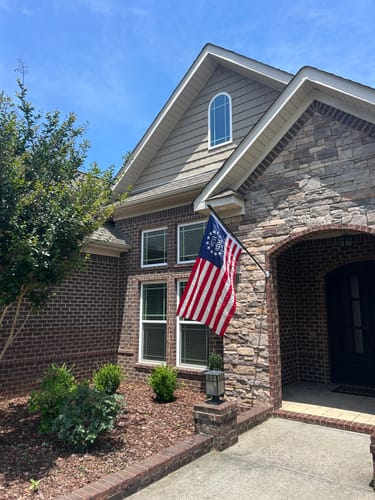 Reviewer's 1776 to 2026 Betsy Ross Flag displayed on a flagpole on the front of their brick and stone home.