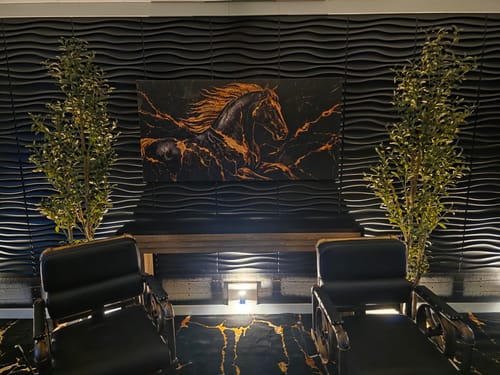 Customer's Obsidian Stallion Majesty canvas displayed on a dark, textured wall in their new podcast studio.