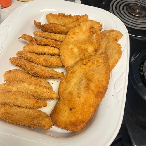 Customer's cooked Halal Chicken Tenders, breaded and golden-brown, arranged on a white serving platter.