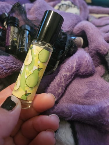 Customer holding the Pear Dream rollerball bottle, showing the pear-patterned label.