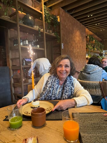 Customer reviewing The Micro Infusion System, smiling at a table in a restaurant.