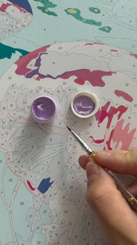 A painter filling in a numbered canvas