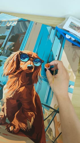 Painting a dog portrait, brush in hand
