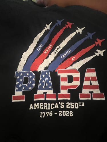 Customer's personalized black shirt showing 'PAPA' in a flag design with custom names and 'America's 250th Anniversary' text.