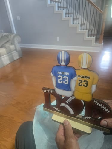 Reviewer holding a custom football-themed Father's Day plaque with two players sharing the same name and number.