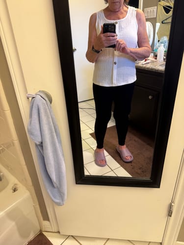 Reviewer in a mirror selfie showing the front view of the black Silix™ Sculpting Leggings, worn with a white top.