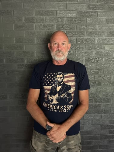 Customer wearing the dark blue Presidential Patriot 250 T-Shirt with its Lincoln and guitar graphic.